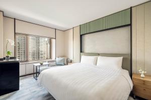 哈尔滨哈尔滨香格里拉的卧室设有一张白色大床和一扇窗户。