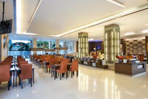 日惹Riss Hotel Malioboro的一间带桌椅的餐厅和一间酒吧
