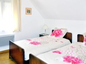 斯特哲兹Maison de 3 chambres avec jardin clos et wifi a Stotzheim的一间卧室配有两张带粉红色鲜花的床。