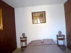 维琪奥港Appartement de 2 chambres avec piscine partagee terrasse et wifi a Porto Vecchio a 3 km de la plage的一间卧室配有床和两张边桌