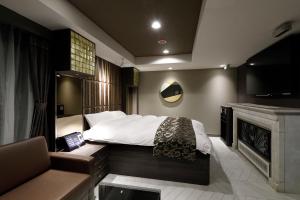 Kiyosuホテルバースデーきよす店 HOTEL Birthday kiyosu的一间卧室配有一张床、一台电视和一张沙发
