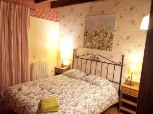 贝尔维尔德赛当亚4 bedrooms house with enclosed garden and wifi at Bellver de Cerdanya的一间卧室配有一张床和两个带灯的床头柜