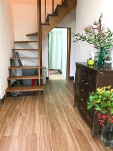热海Guesthouse Nishihara的一间铺有木地板并设有一个楼梯的客厅