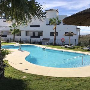圣路易斯·德·萨比尼尔2 bedrooms appartement with sea view shared pool and furnished garden at Malaga 2 km away from the beach的大楼前的游泳池