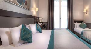 巴黎塞拉米克爱丽舍酒店的一间卧室配有两张带白色和蓝色枕头的床