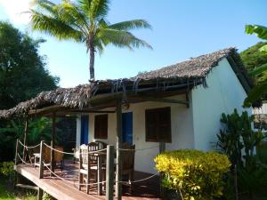 安迪拉纳2 bedrooms bungalow with sea view shared pool and enclosed garden at Andilana的棕榈树白色的小房子