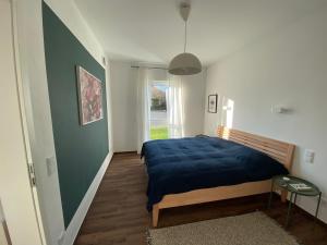 施瓦姆施泰特Ferienwohnung Zum Kiessee的一间卧室配有一张带蓝色毯子的床