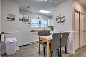 海泉市Downtown Ocean Springs Duplex with AandC 1 Mi to Beach的厨房配有桌椅和冰箱。