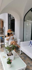 马拉泰亚穆曼酒店的坐在白色沙发上戴帽子的女人
