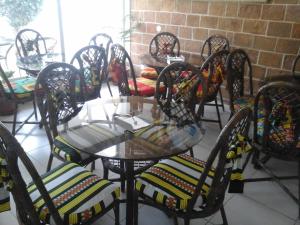 马约城Hotel AH Maio的一套椅子和一张玻璃桌