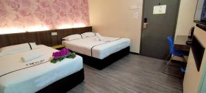 吉隆坡吉隆坡富都蕉赖微笑酒店的酒店客房,配有两张带鲜花的床