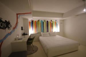 高雄Hotel Papa Whale-高雄美丽岛馆的一间卧室配有一张床、一张书桌和一个窗户。