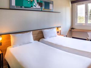 门多萨宜必思酒店客房内的一张或多张床位
