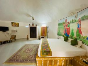 曼达瓦Desert Nights的卧室配有一张大床,墙上挂有绘画作品