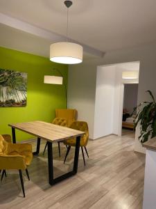 莱斯诺夫Apartamente Bucegi的一间带桌子和黄色椅子的用餐室
