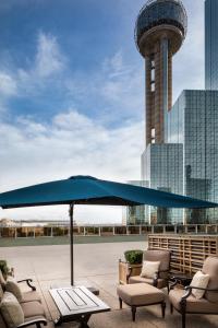 达拉斯达拉斯凯悦大酒店的露台上的大蓝伞,带椅子和塔