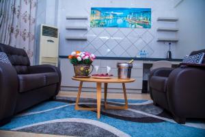 达累斯萨拉姆马缨丹酒店 的客厅设有两张沙发和一张带鲜花的桌子