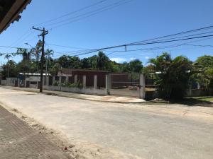 乌巴图巴Farol da Barra Seca Ubatuba的一条有栅栏和棕榈树的空街道