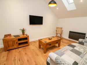 柯比斯蒂芬Macaw Cottages, No 4A的客厅配有沙发和墙上的电视