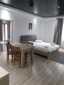 上维谢乌Happy Residence的一间设有两张床和一张桌子及椅子的房间