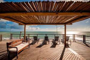 纳塔尔纳塔尔波图套房酒店的海滩上带椅子和长凳的木制甲板