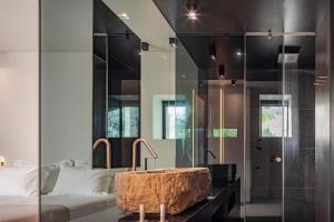 KomiaMilos Cove的卧室中间设有带浴缸的浴室