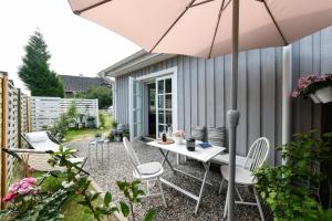 汉堡Boje 16的庭院配有桌椅和遮阳伞。