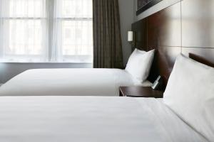 旧金山Club Quarters Hotel Embarcadero, San Francisco的酒店客房设有两张床和窗户。