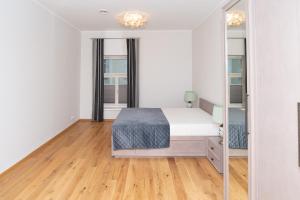 塔尔图Lossi 32 Luxury Apartment with Sauna的白色卧室配有床和镜子
