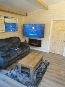 BoyhollaghThe Lodge Mountain View Log Cabin , Attymass Ballina的带沙发、桌子和电视的客厅