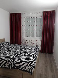 锡纳亚Apartament Elena的一间卧室配有黑白床和红色窗帘