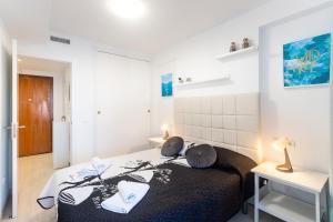 贝尼多姆TROPIC MAR Levante beach apartments的一间卧室配有一张床,上面有两条毛巾