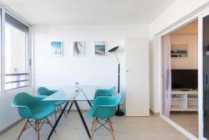 贝尼多姆TROPIC MAR Levante beach apartments的一间设有玻璃桌和蓝色椅子的用餐室
