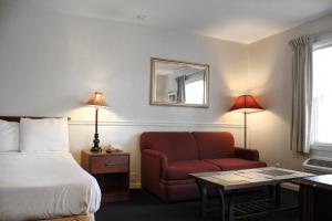 罗克福德罗克福德阿尔卑斯套房酒店的酒店客房,配有一张床和一张红色椅子