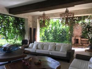 圣地亚哥洛斯卡巴Casa Tropical con Hermosos Atardeceres Caribeños的客厅配有白色沙发和大窗户