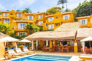 布希奥斯Bahiamarela Boutique Hotel & SPA的一座带游泳池和黄色建筑的度假村