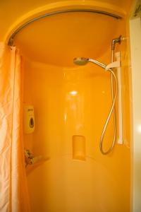 克莱蒙费朗北克莱蒙费朗普瑞米尔经典酒店的浴室设有黄色墙壁,配有淋浴。