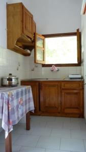 罗达亚历山德拉公寓的厨房配有木制橱柜、桌子和窗户。