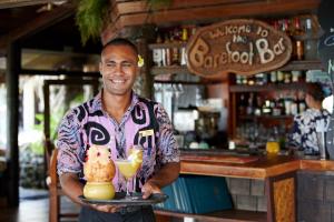 拉罗汤加拉罗汤加岛太平洋度假酒店的拿着托盘喝着的男人和一只猫
