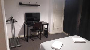 阿让Chambres d'Hotes Centre Ville的客房设有书桌、电视和桌椅