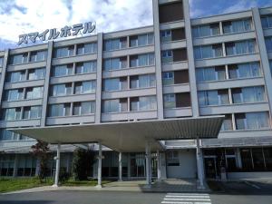 NishigoSmile Hotel Shirakawa的一座酒店大楼,上面有标志