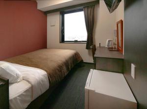 铃鹿市Hotel Trend Suzuka的酒店客房设有两张床和窗户。