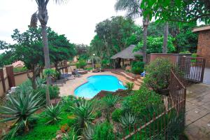 比勒陀利亚Upmarket Villa with pool & lush garden的后院设有游泳池和凉亭
