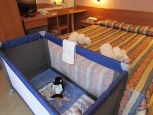 维耶斯泰帕尔梅葛美乐酒店的一张位于酒店客房的床铺,配有婴儿床