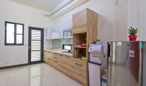 Yujing玉井·艺海民宿的厨房配有不锈钢冰箱和木制橱柜