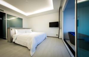 奥南海滩Krabi Tipa Resort - SHA EXTRA PLUS的卧室配有白色的床和电视