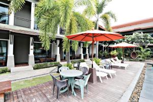 七岩P' Private Resort Cha Am的一个带桌椅和遮阳伞的户外庭院。