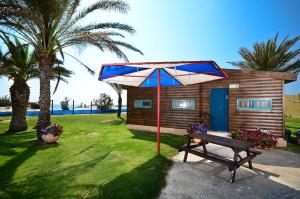 DorDor al Hayam的小屋配有长凳和遮阳伞