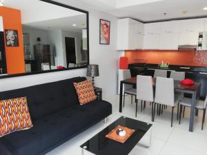 纳苏格布Lagoon view Family Suite in Pico De Loro Cove, Nasugbu的客厅配有黑色沙发和桌子