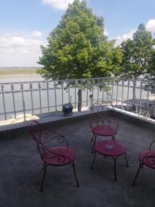 索姆河畔的圣瓦列里Logis Hôtel- Restaurant Le Relais Guillaume de Normandy的一组椅子坐在俯瞰水面的阳台